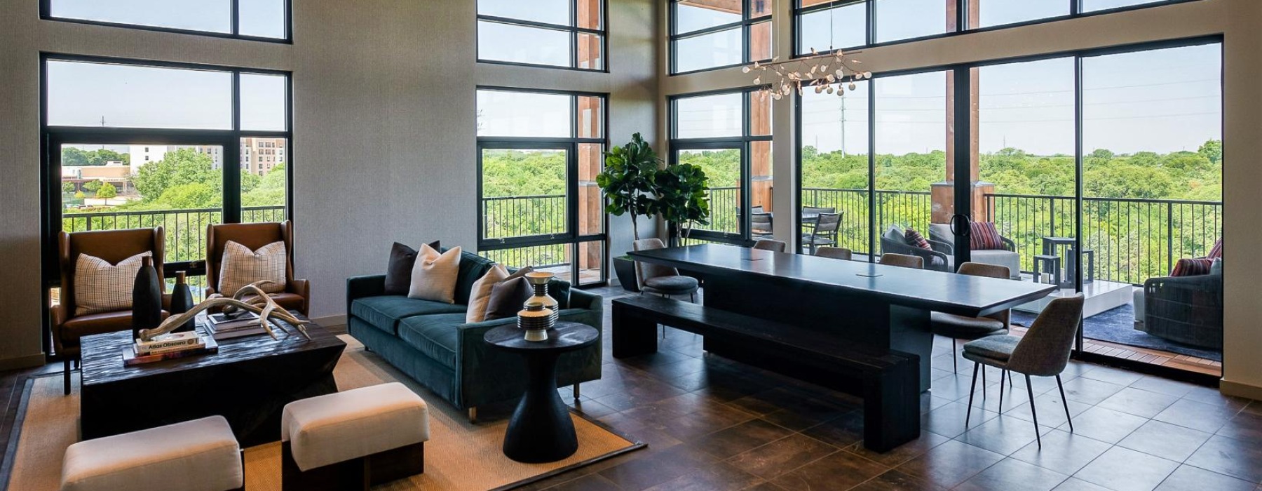 Resident lounge at our apartments for rent in Grapevine, TX, featuring tiled flooring, couches, and a balcony with a view.