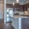 Model kitchen at our apartments for rent in Grapevine, TX, featuring wood grain flooring and a kitchen island.