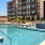 The pool area at our apartments for rent in Grapevine, TX, featuring lounge chairs and a view of the apartment exteriors.
