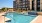 The pool area at our apartments for rent in Grapevine, TX, featuring lounge chairs and a view of the apartment exteriors.